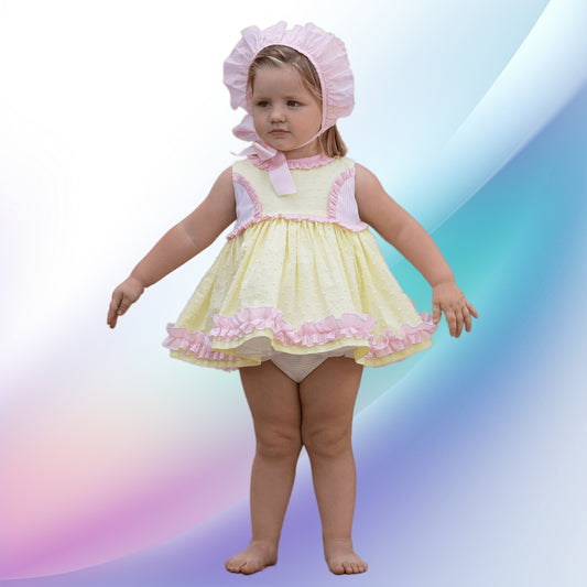Image of a vintage yellow and pink dress and diadem set by Abuela Tata, ideal for a baby or toddler attending a party or wedding. The soft, lightweight, machine-washable dress features charming ruffle trims, stripes, plumeti detailing, pearly pink back buttons, and a fixed sash tie for easy wear.