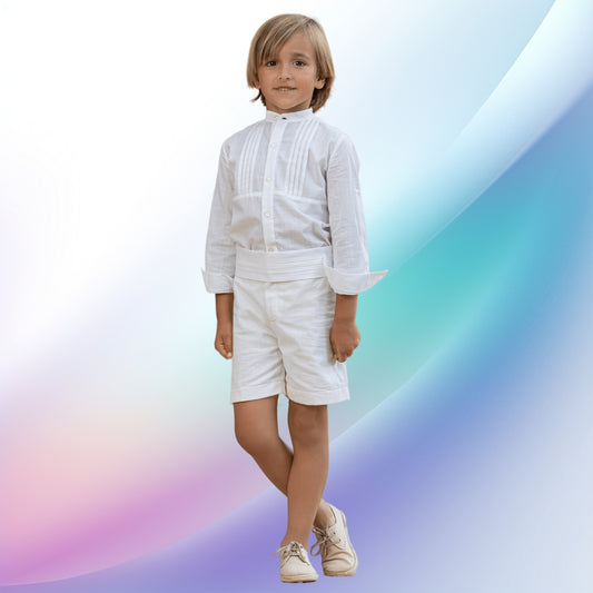 A classic off-white boy's ceremony outfit, perfect for church events, first communions, weddings, or as a ring bearer's ensemble. The handcrafted European-style outfit features a shirt with matching stitch details and cotton shorts, paired with an elegant sash, ensuring your little man is the star of the show.