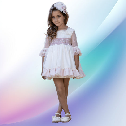 Image of an adorable off-white and pale pink girl's ceremony dress and diadem, perfect for weddings, church events, or first communions. The beautifully handcrafted dress features a lace-trimmed square neck, tulle sleeves, a multi-layered skirt with pink tulle, and a back bow. A matching flower-adorned headband completes this charming flower girl outfit.